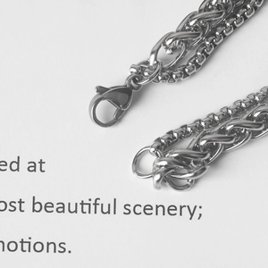 Macro shot of silver stainless steel double layer chain with lobster clasp and box link detail