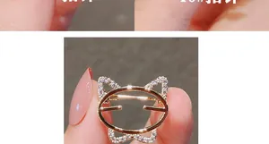 Gros plan d'une broche chat dorée minimaliste avec incrustations de zircon sur un doigt