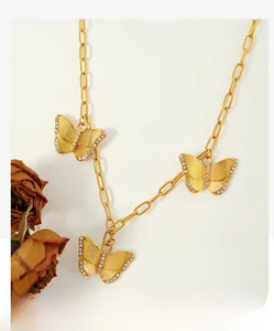 Detail of gold butterfly necklace with paperclip chain and sparkling zircon stones