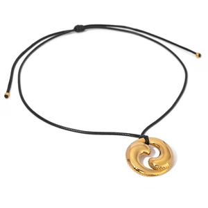 Golden swirl pendant necklace with black braided cord and adjustable metal ends