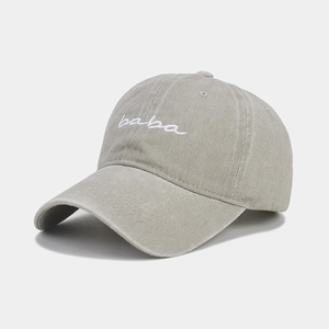 Gros plan sur la broderie baba blanche sur la casquette en coton gris clair délavé