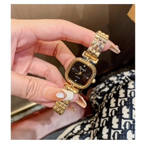 Close-up of a stylish square gold watch with black dial worn on a woman's wrist