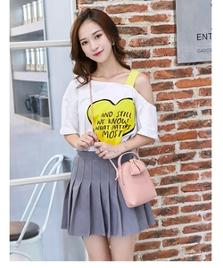 Pink mini crossbody bag with handle and bow decoration shown in an outdoor lifestyle setting