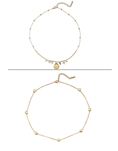 Détail du collier à pendentif coquillage doré 18 carats et chaîne à breloques cœurs