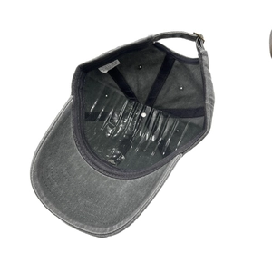 Detail view of cotton baseball cap interior with 100% cotton label and metal buckle