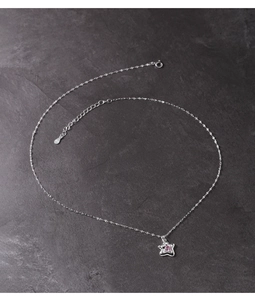 Detailed close-up of s925 silver star pendant with pink zircon on grey stone background