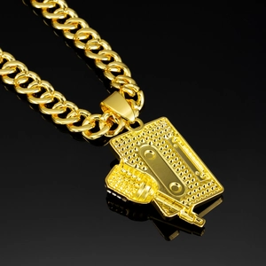 Close-up of hip-hop golden Cuban chain with detailed microphone and tape pendant
