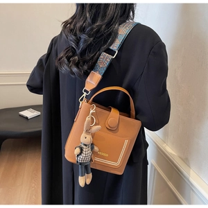 Brown PU leather crossbody bag featuring a floral wide strap and rabbit plush charm