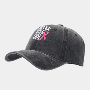 Détail du ruban contre le cancer du sein et broderie 'Never Give Up' sur la casquette grise