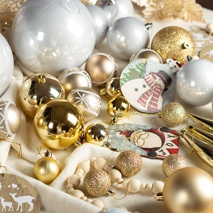 Flat lay of gold and silver Christmas ornaments with wooden snowmen and beaded garlands