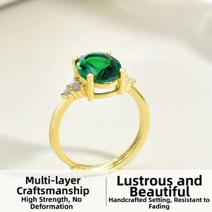 Close-up of gold-plated ring featuring an oval emerald-cut green stone and side zircons
