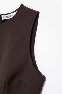 Detail of dark brown layered mesh fabric texture and size label on sleeveless dress