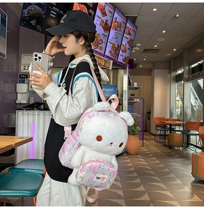 Close-up of white plush bunny backpack with pink gradient straps and princess label