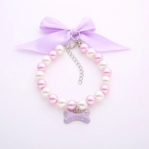 Pink and white pearl pet collar with a purple satin bow and rhinestone bone pendant
