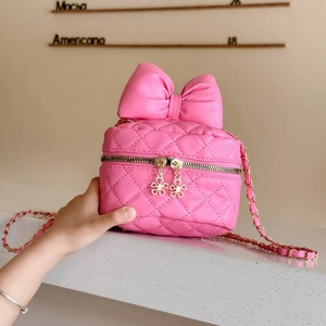 Pink quilted crossbody bag with large bow detail and gold chain strap for women