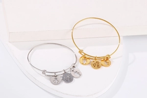 Detail of adjustable titanium steel bracelets in gold and silver with Love charms