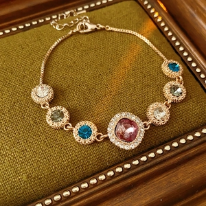 Detail of rose gold bracelet featuring colorful zircon stones and vintage round gems