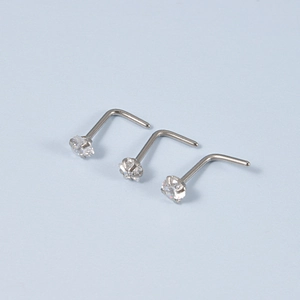 Detailed view of three silver L-shaped nose studs featuring clear round zircon stones