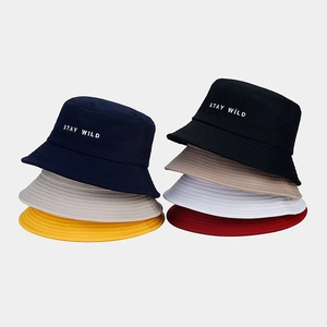 Détails de plusieurs bobs en coton de différentes couleurs avec broderie Stay Wild