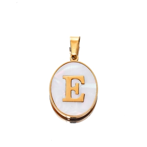 Close-up of golden oval pendant with white shell inlay featuring the letter E detail