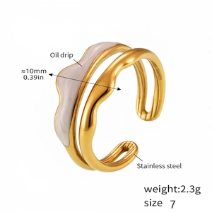 Detail of golden stainless steel wavy ring with white oil drip finish and 18k PVD plating