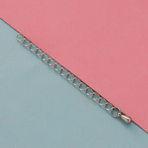 Detail of silver stainless steel extender chain with drop pendant on dual-tone background