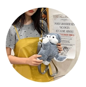 Detailed view of the cute grey plush animal crossbody bag worn by a model in a casual outfit