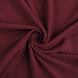 Gros plan du tissu scintillant à paillettes rouge foncé avec plis élégants