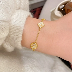 Bracciale a fiori placcato oro 18 carati con madreperla e zircone su polso femminile