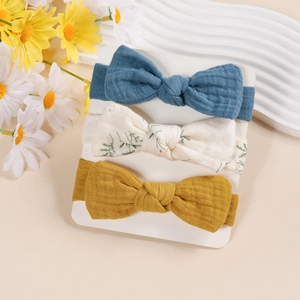 Vue détaillée de trois bandeaux pour bébé en coton crépon avec de grands nœuds colorés