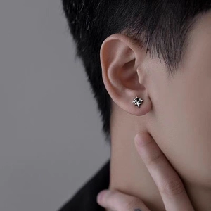 Titanium steel eight-pointed star stud earring with black zircon stone on earlobe