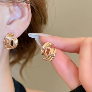 Geometric gold spiral striped stud earrings with layered interlocking curved design