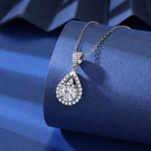Close-up of a pear-shaped pendant with a large round zircon on a blue pedestal