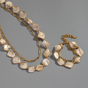Detail of baroque shell beads and stainless steel chain necklace and bracelet set