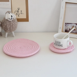 Close-up of pink cotton woven coasters and placemats with a spiral texture design