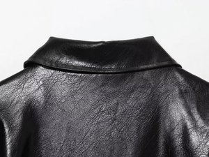 Détails de la texture en similicuir noir et des coutures du col et du dos de la veste