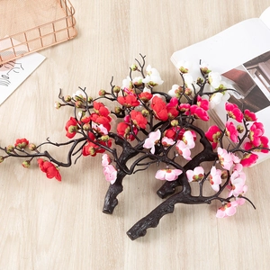 Detailed close-up of artificial plum blossom branches in red pink and white colors