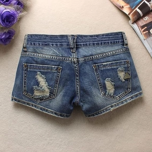 Détail du short en jean bleu montrant des effets usés et des poches arrière doubles