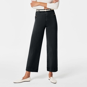 Close-up of high-waisted wide-leg jeans with decorative button detail on dark denim fabric