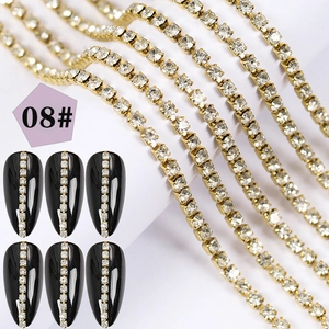 Detailed view of gold rhinestone chains for nail art with a black manicure application
