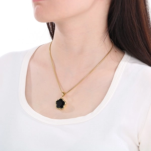 Fashionable gold snake chain necklace with black five-petal flower pendant on female model