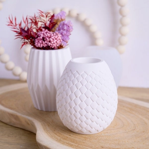 Détail du moule à vase cylindrique en résine avec texture d'écailles et fleurs séchées