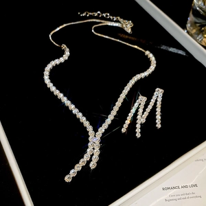 Detail view of zircon geometric tassel necklace and earrings set in premium gift box