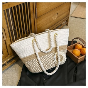 Detailed close-up of woven tote bag featuring cotton straw texture and sunflower ornament