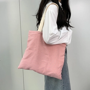 Minimalist red and white striped canvas tote bag shown at a 45-degree angle on a model
