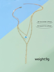 Double-layered evil eye gold tassel necklace with Y-shaped design and blue round pendant