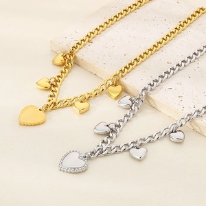 Detail of gold and silver cuban link necklaces with multiple heart shaped pendants