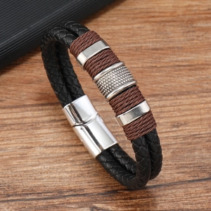 Detail of double-layer woven leather bracelet with silver magnetic clasp on wood