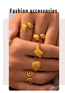 Close-up of a 18k gold-plated ring set featuring leaf, wave, and spiral textured designs