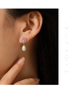 Close-up of elegant s925 silver heart earring with pink zircon and white drop pearl
